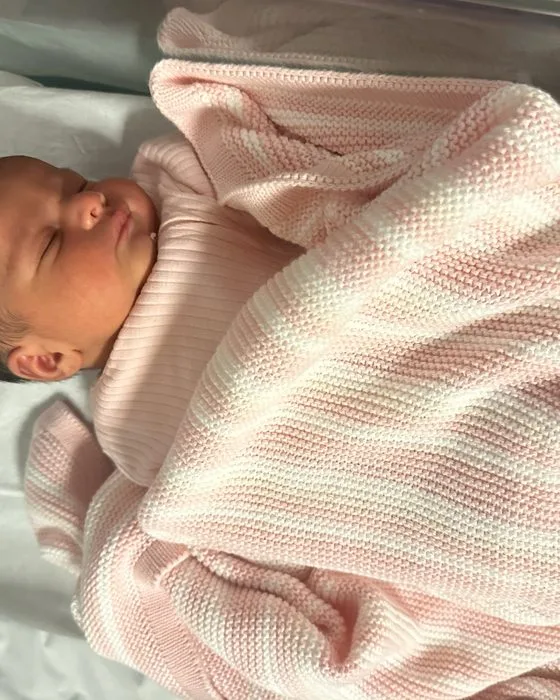 Yusra as a newborn, swaddled in a pink blanket